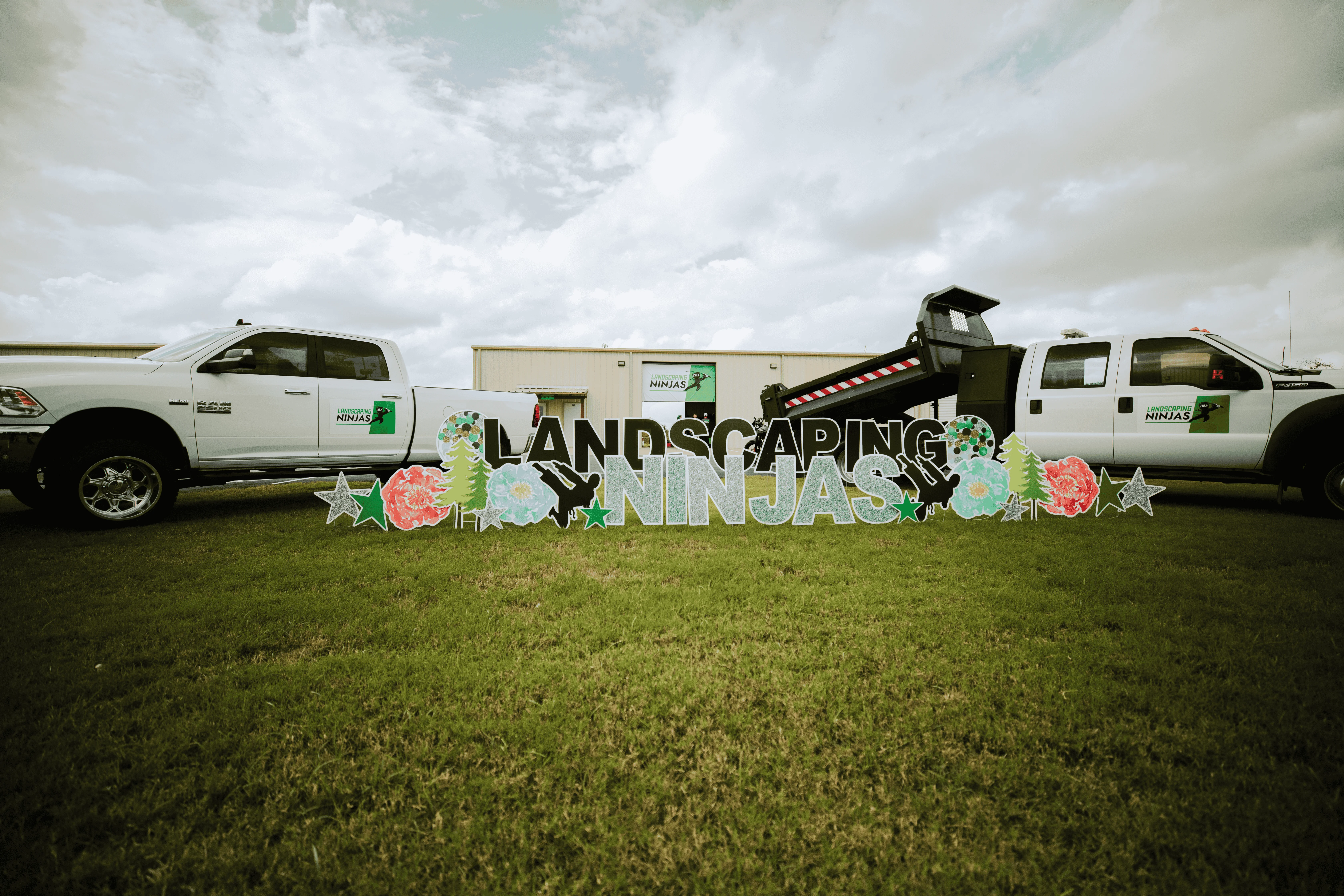 Landscaping Ninjas branded trucks and signage on a green lawn in College Station, TX.