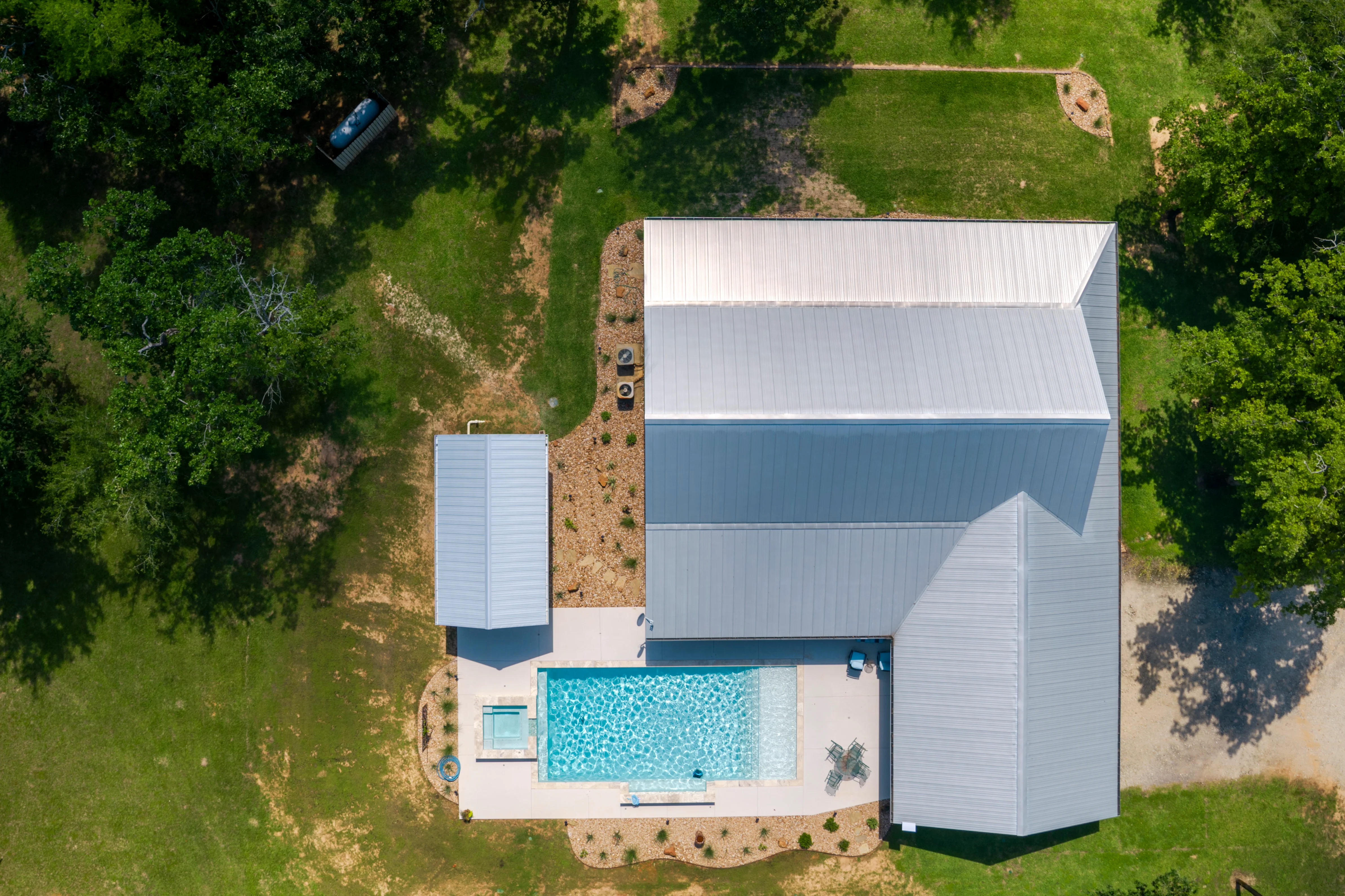 Aerial view of modern home with new pool, concrete patio, and freshly graded grounds — Grading Contractor by Landscaping Ninjas in College Station, TX